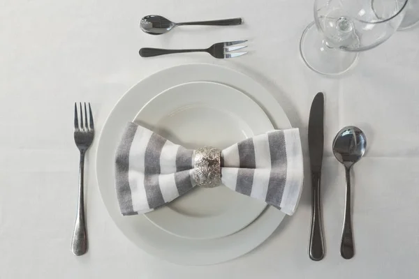 Prato e talheres ajustados elegantemente em uma mesa — Fotografia de Stock