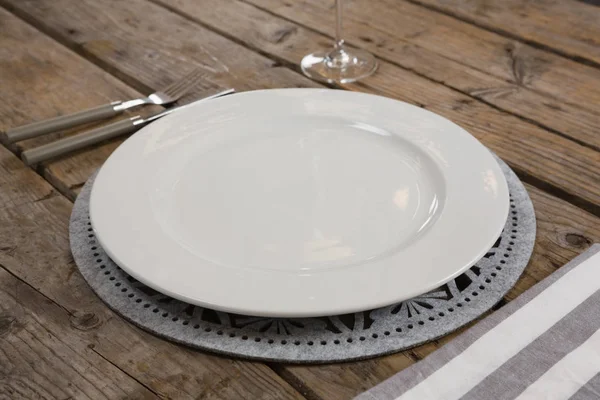 Placa y servilleta con tenedor en mesa de madera — Foto de Stock