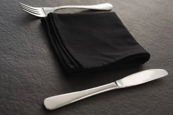 Πιρούνι, κουτάλι και ένα μαύρο χαρτοπετσέτας για τραπέζι — Φωτογραφία Αρχείου