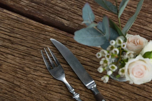 Gaffel och smör kniv med blomma på bordet — Stockfoto