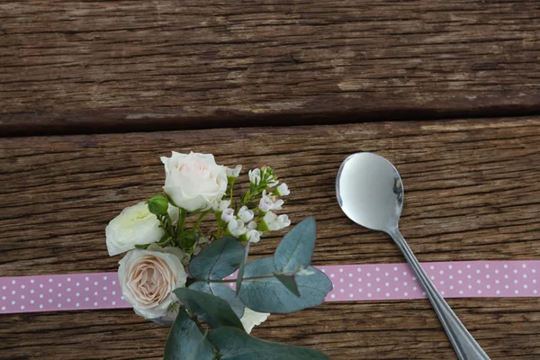 Flor de rosa com colher e fita na mesa — Fotografia de Stock