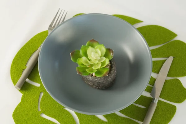 Blomma i skål med gaffel på ett bord — Stockfoto