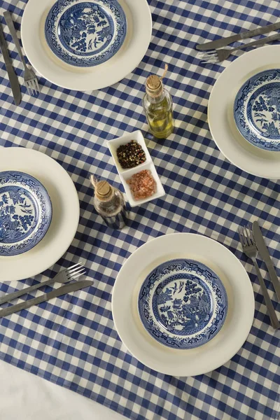 Borden, bestek, specerijen en olijfolie — Stockfoto