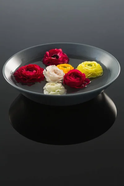 Róże w szklanej misce z wodą — Zdjęcie stockowe