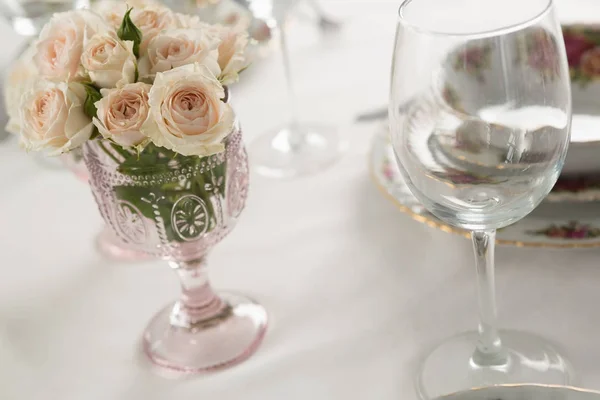 Glas vin och blommor på ett matbord — Stockfoto