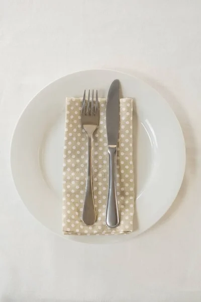 Forchetta con tovagliolo disposti in un piatto — Foto Stock