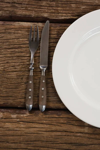 Πλάκα με πιρούνι και βουτύρου μαχαίρι στο τραπέζι — Φωτογραφία Αρχείου