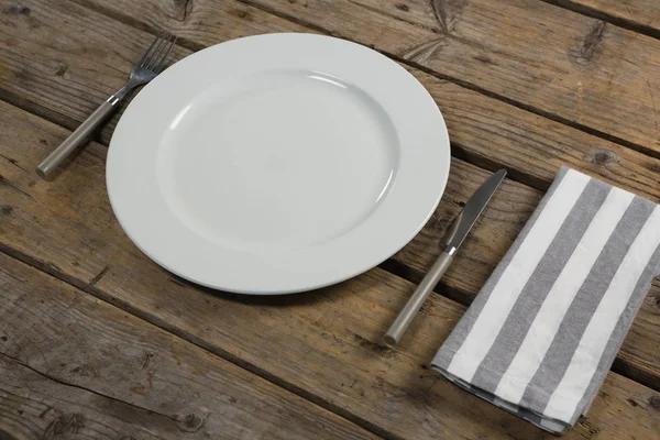 Prato com talheres e guardanapo na mesa — Fotografia de Stock