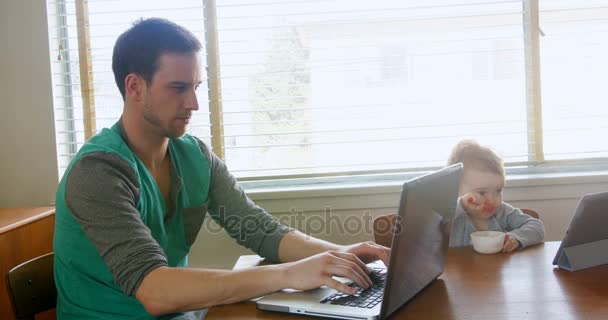 Father using laptop while baby — Stock Video