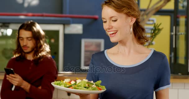Serveerster houden een bord van salade — Stockvideo