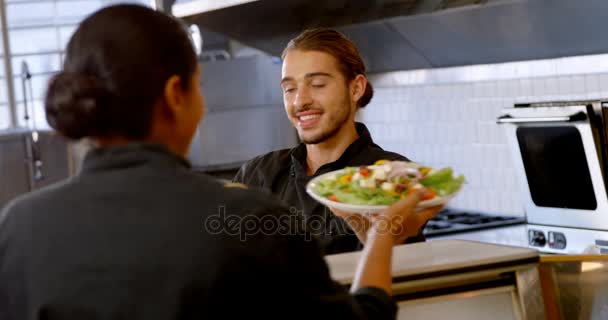 Chef entregando platos de comida a la camarera — Vídeos de Stock