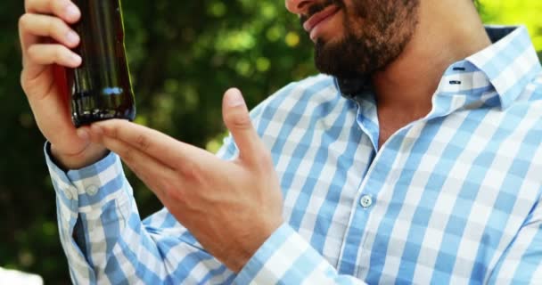 Homme tenant une bouteille de bière dans le parc — Video