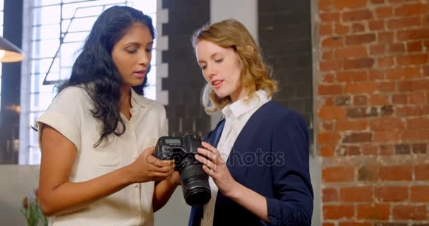 Executives discussing over digital camera — Stock Video