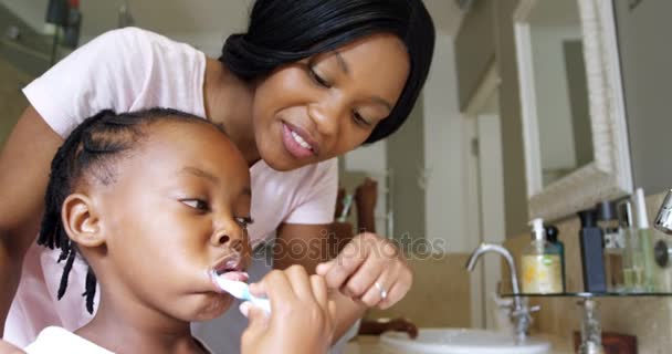 Мать учит дочь чистить зубы — стоковое видео