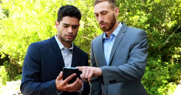 Businessmen discussing over mobile phone — Stock Video