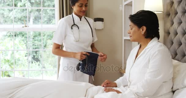 Doctor measuring blood pressure of woman — Stock Video