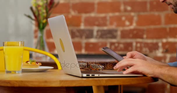 Bonito Homem Usando Telefone Celular Laptop Mesa Café — Vídeo de Stock