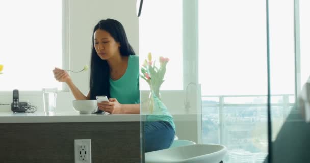 Mujer usando el teléfono móvil mientras — Vídeo de stock