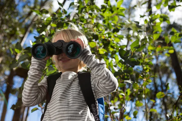 Girl looking through binoculars — Stock Photo, Image