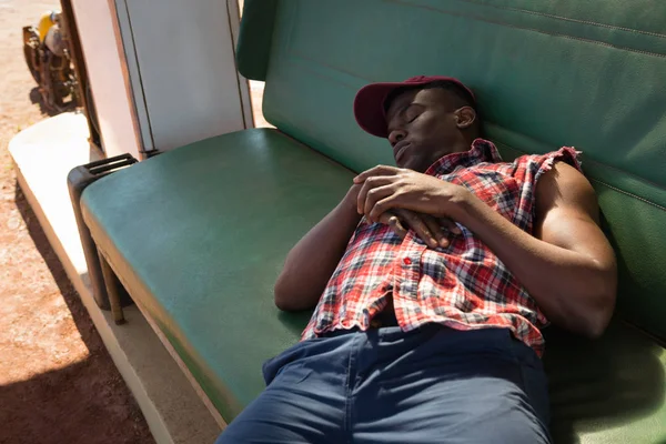 Man sleeping at petrol pump station — Stock Photo, Image