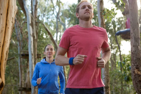 Mężczyzna i kobieta jogging w lesie — Zdjęcie stockowe