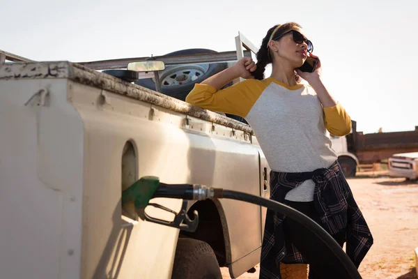 Kobieta rozmawia telefon podczas napełniania benzyna — Zdjęcie stockowe
