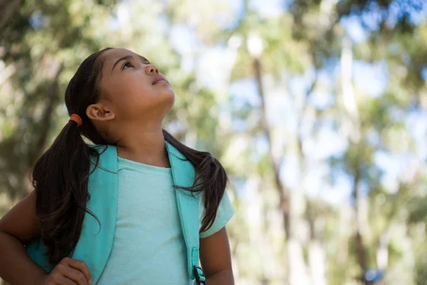 Girl standing with backpack looking up — Stock Photo, Image