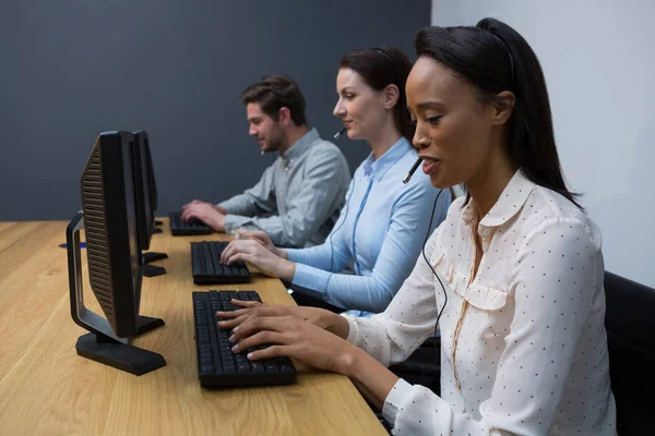 Företagsledare med headset använder datorer — Stockfoto