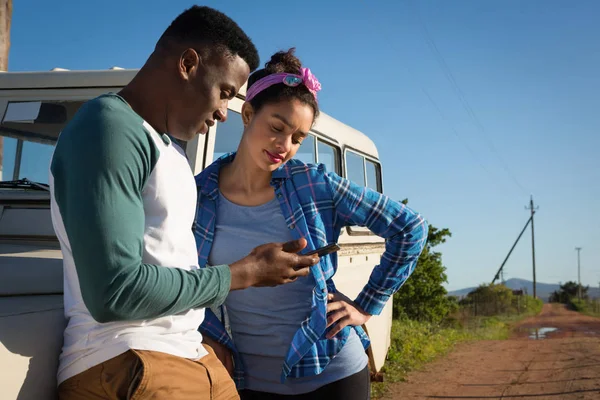 Couple using mobile phone at countryside — Stock Photo, Image