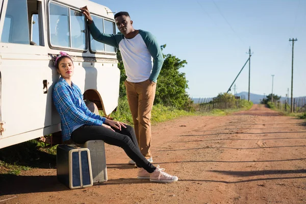 Paar zittend op koffer op platteland — Stockfoto