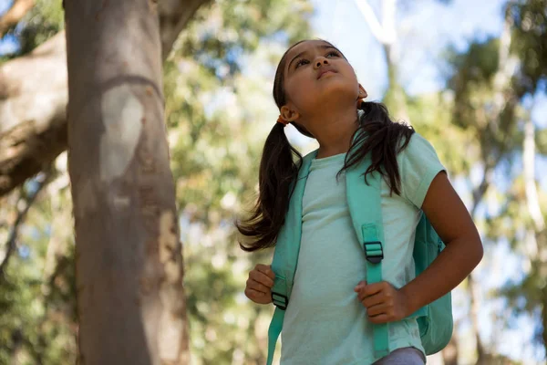 Girl standing with backpack looking up — Stock Photo, Image