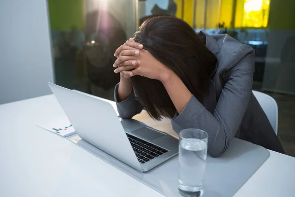 Angespannte Geschäftsfrau sitzt mit Laptop — Stockfoto