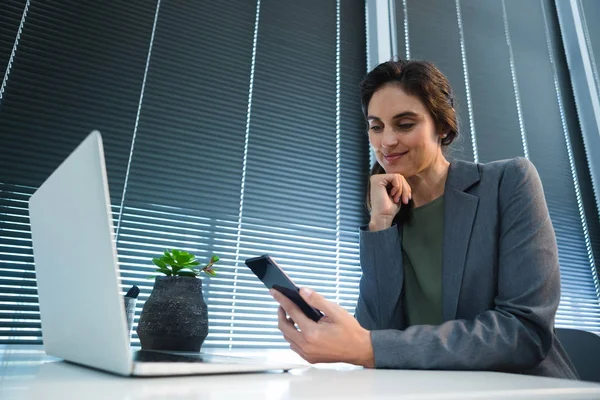 Mujer ejecutiva usando el teléfono en el escritorio — Foto de Stock