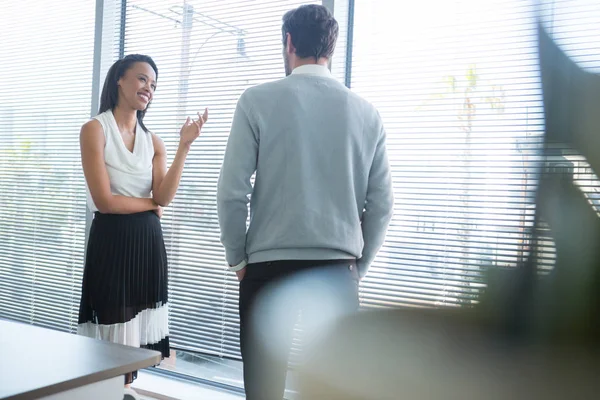 Male and female executives interacting with each other — Stock Photo, Image