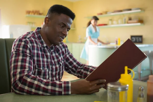 Uomo guardando il menu nel ristorante — Foto Stock