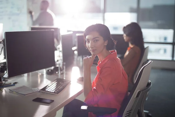 Weibliche Führungskraft sitzt am Schreibtisch im Büro — Stockfoto