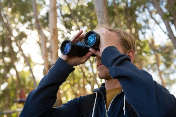 Hombre excursionista explorando la naturaleza a través de prismáticos —  Fotos de Stock