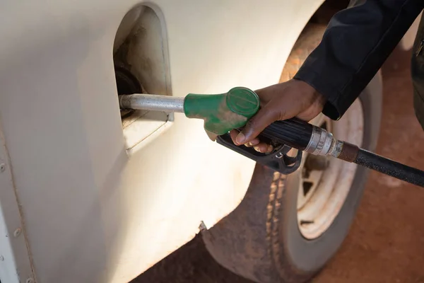 Mies tankkaamassa bensiiniä autossa bensiinipumpussa — kuvapankkivalokuva
