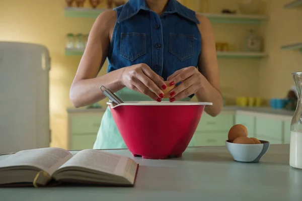 Kvinnan att bryta ett ägg i blandning skål — Stockfoto