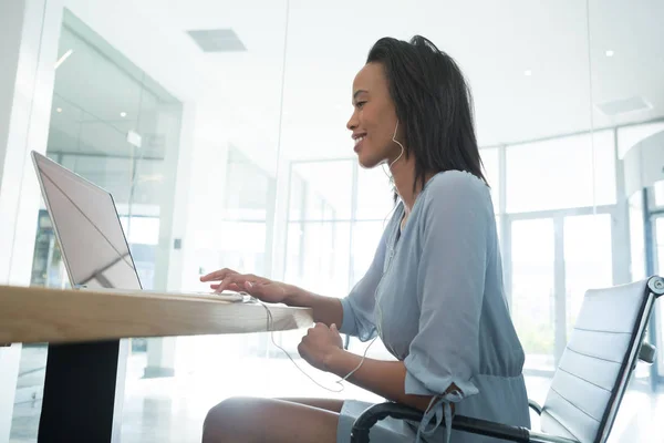 Female executive listening music — Stock Photo, Image