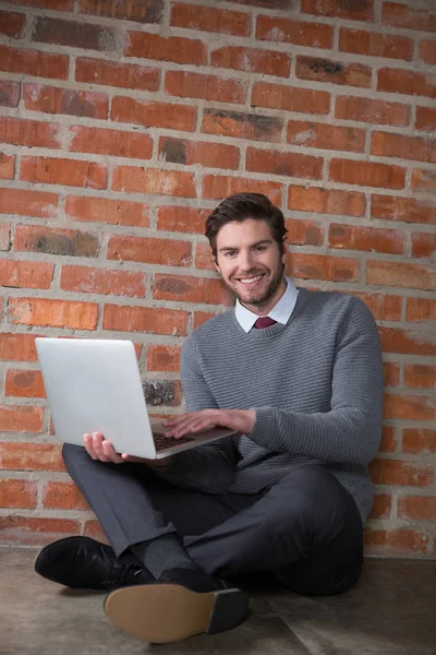 Executivo sorrindo usando laptop — Fotografia de Stock
