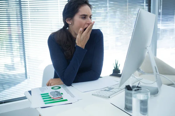 Trött kvinnliga verkställande gäspningar på skrivbord — Stockfoto