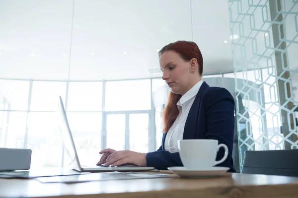 Executivo feminino usando laptop na mesa — Fotografia de Stock