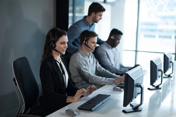 Entrenadora ejecutiva de servicio al cliente monitoreando su equipo — Foto de Stock