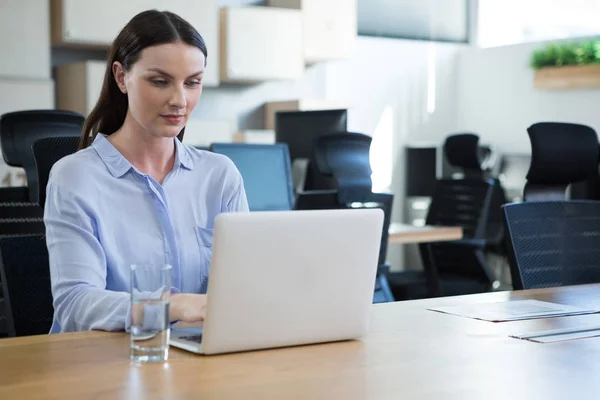 Executivo feminino usando laptop na mesa — Fotografia de Stock