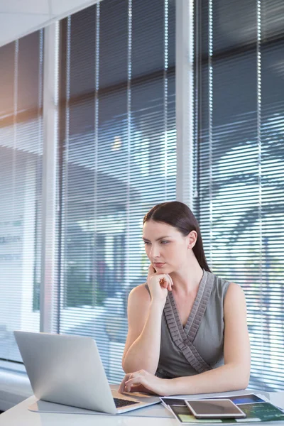 Kvinnliga verkställande använder laptop på skrivbord — Stockfoto