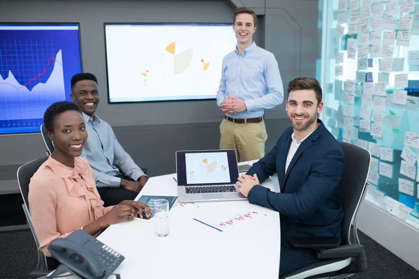 Mannelijke en vrouwelijke leidinggevenden bespreken over grafiek — Stockfoto