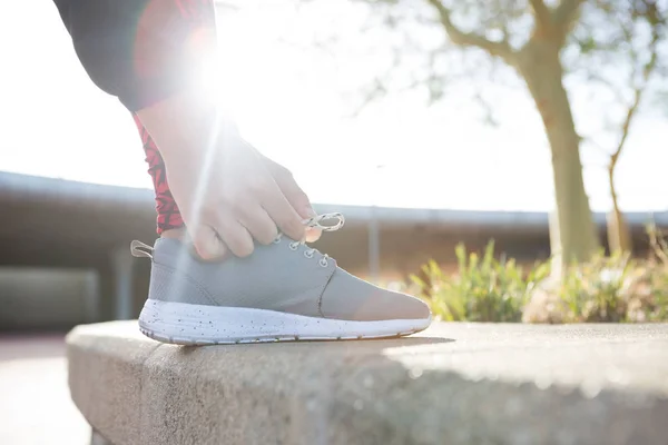 Corredor mujer atándose los cordones de los zapatos — Foto de Stock