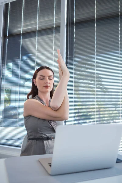 Executivo feminino realizando ioga — Fotografia de Stock