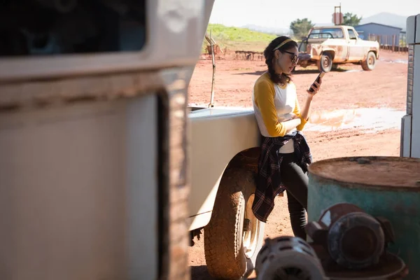 Mujer usando teléfono en la gasolinera — Foto de Stock